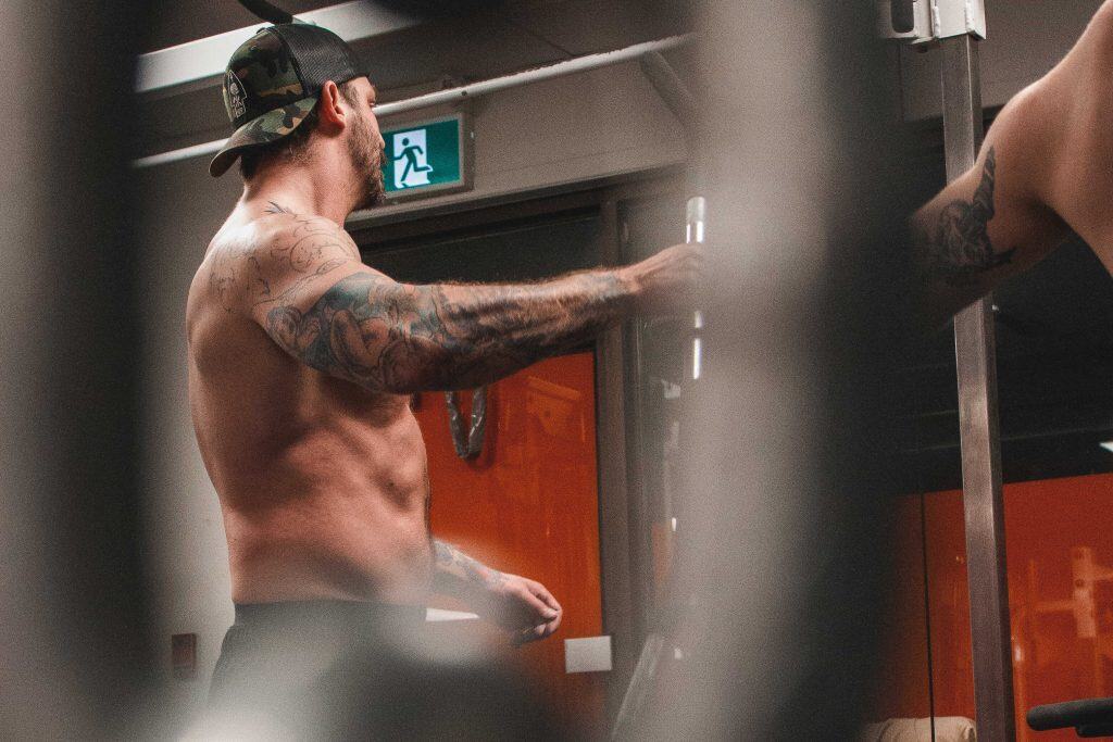 Équipe avec un entraîneur et un client à l'entraînement dans un gym semi-privé